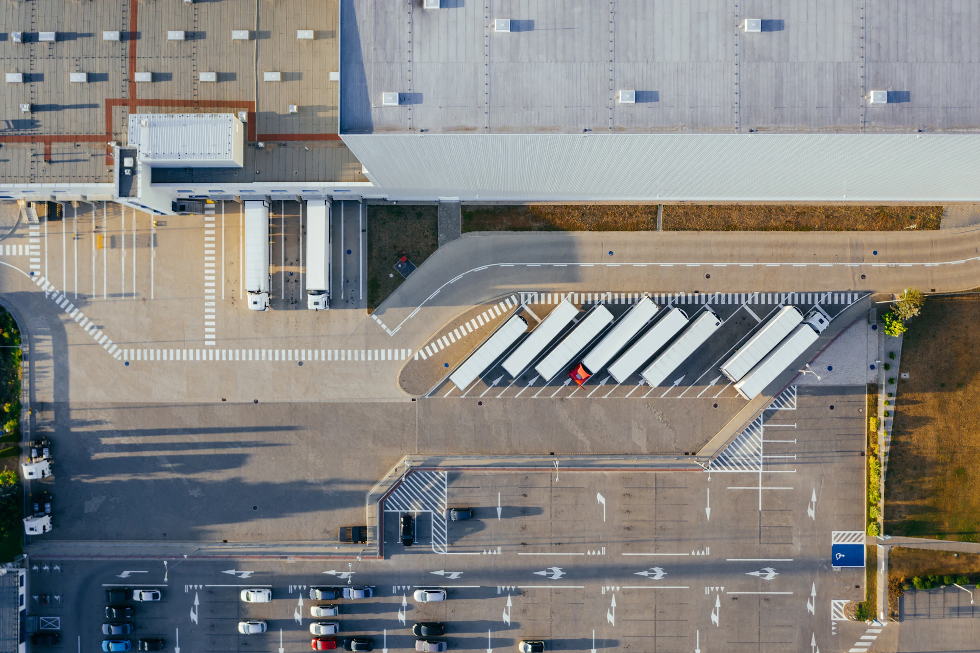 Fleet of branded trucks lined up outside a modern distribution center ready for dispatch.