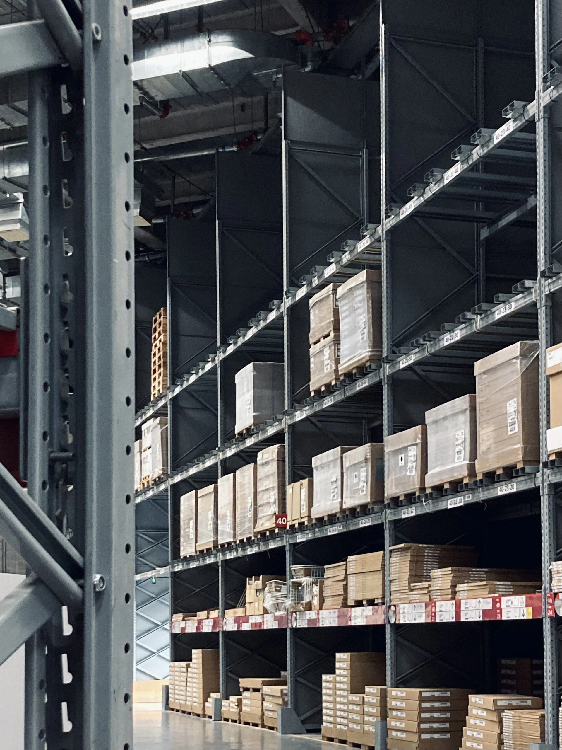 Wide-angle shot of a spacious, organized warehouse with rows of pet food pallets under soft industrial lighting